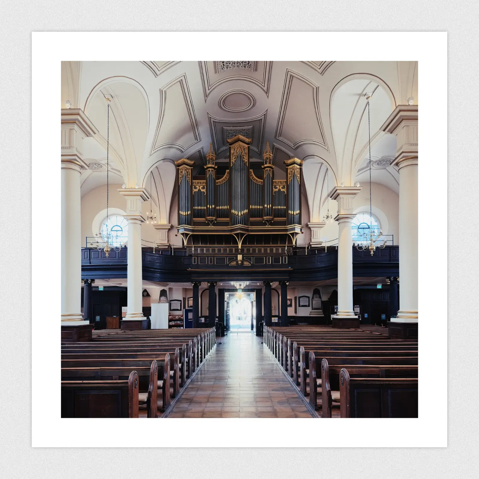 The inside of a symmetrical cathedral looking out towards the door.