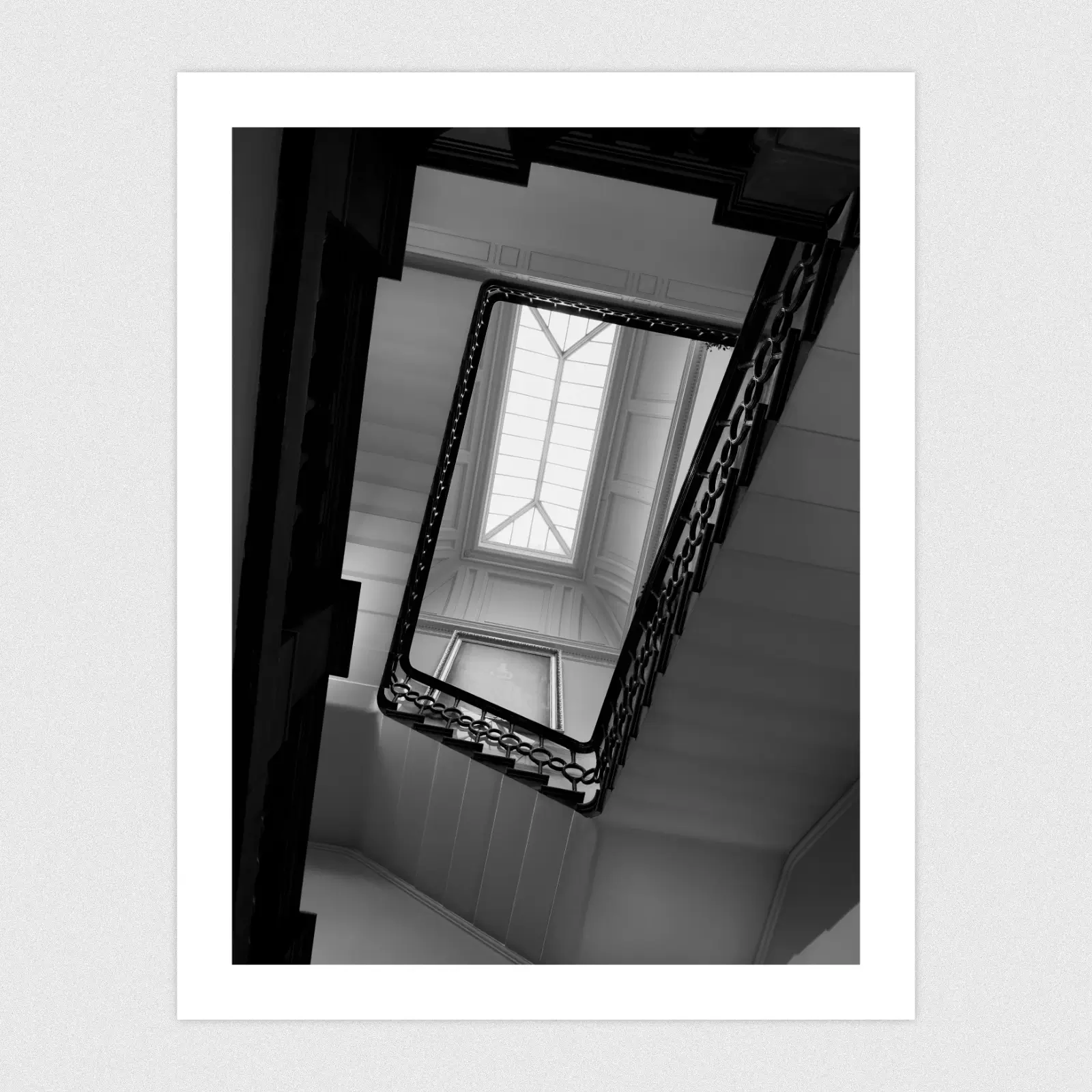 Portfolio Looking up towards a ceiling window from the bottom of a spiral staircase.
