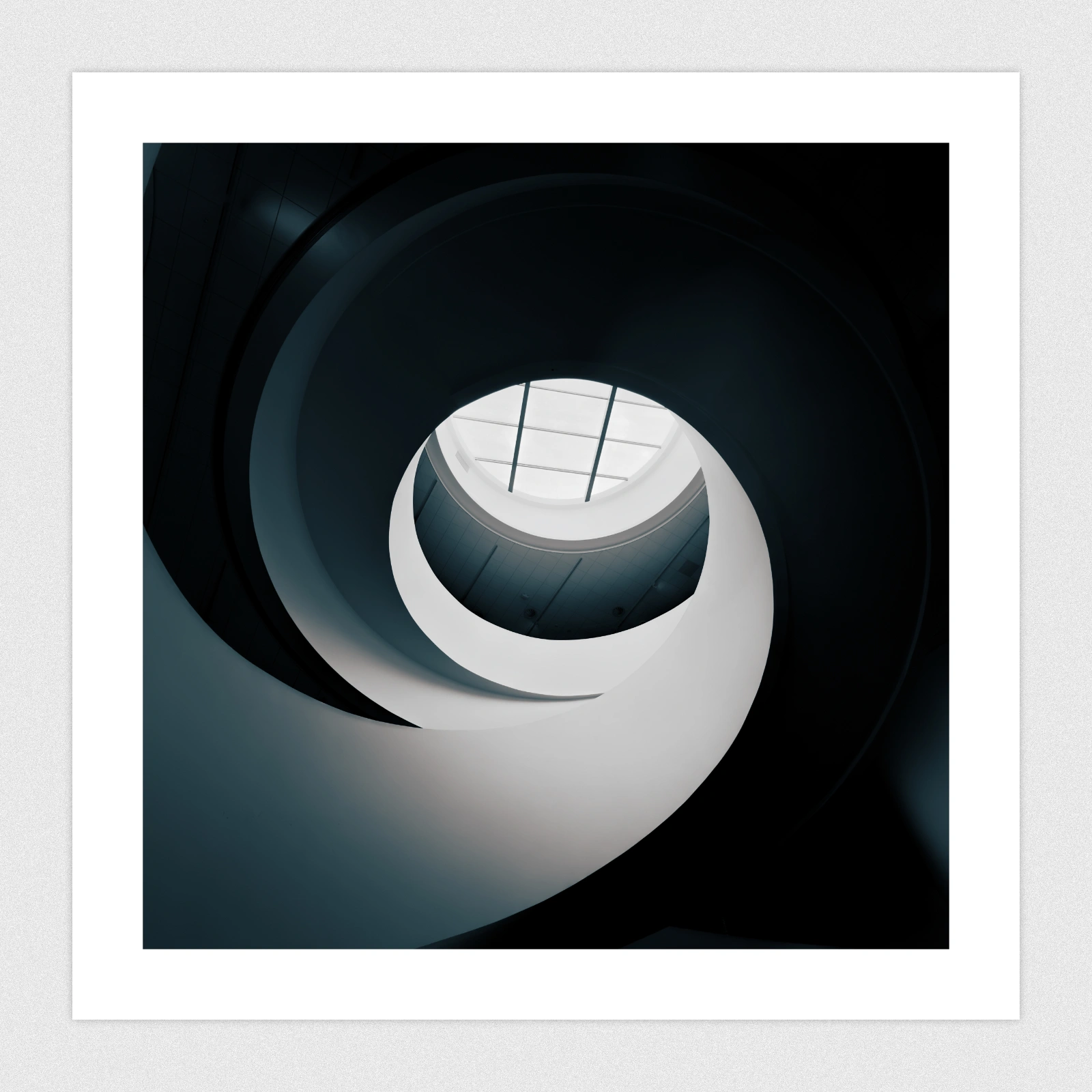 Portfolio A spiral staircase leading up towards a ceiling window.