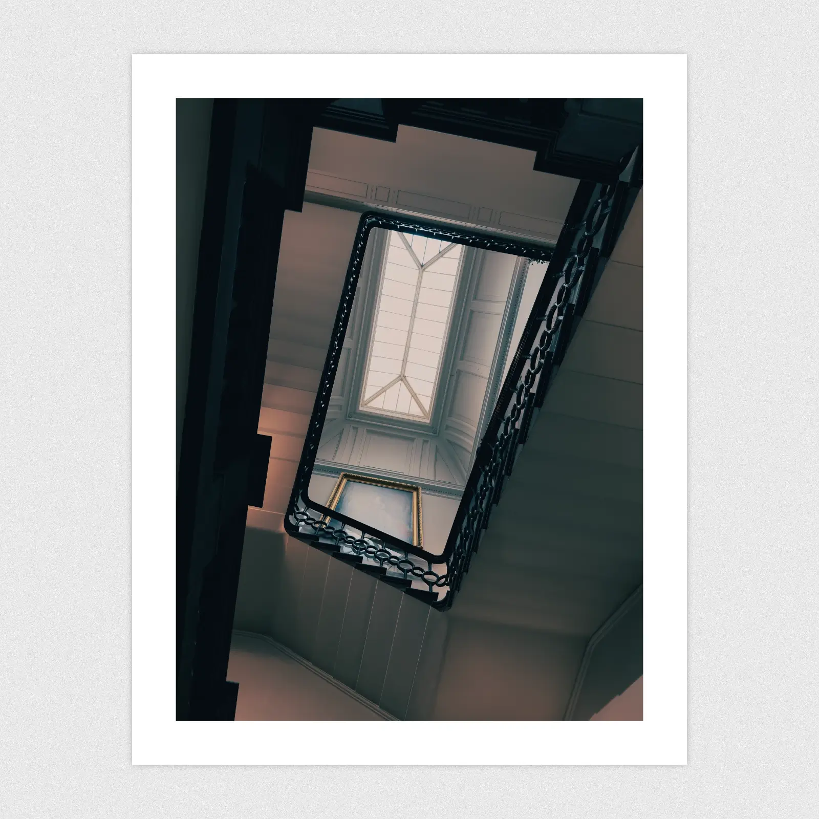 Portfolio Looking up towards a ceiling window from the bottom of a spiral staircase.
