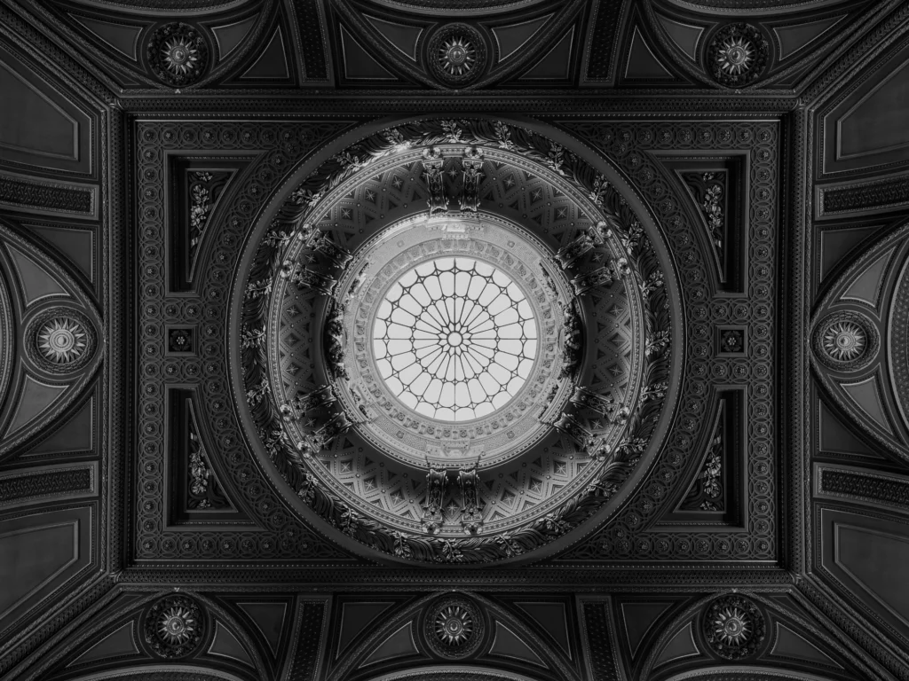 An ornate ceiling with a glass dome in the centre.
