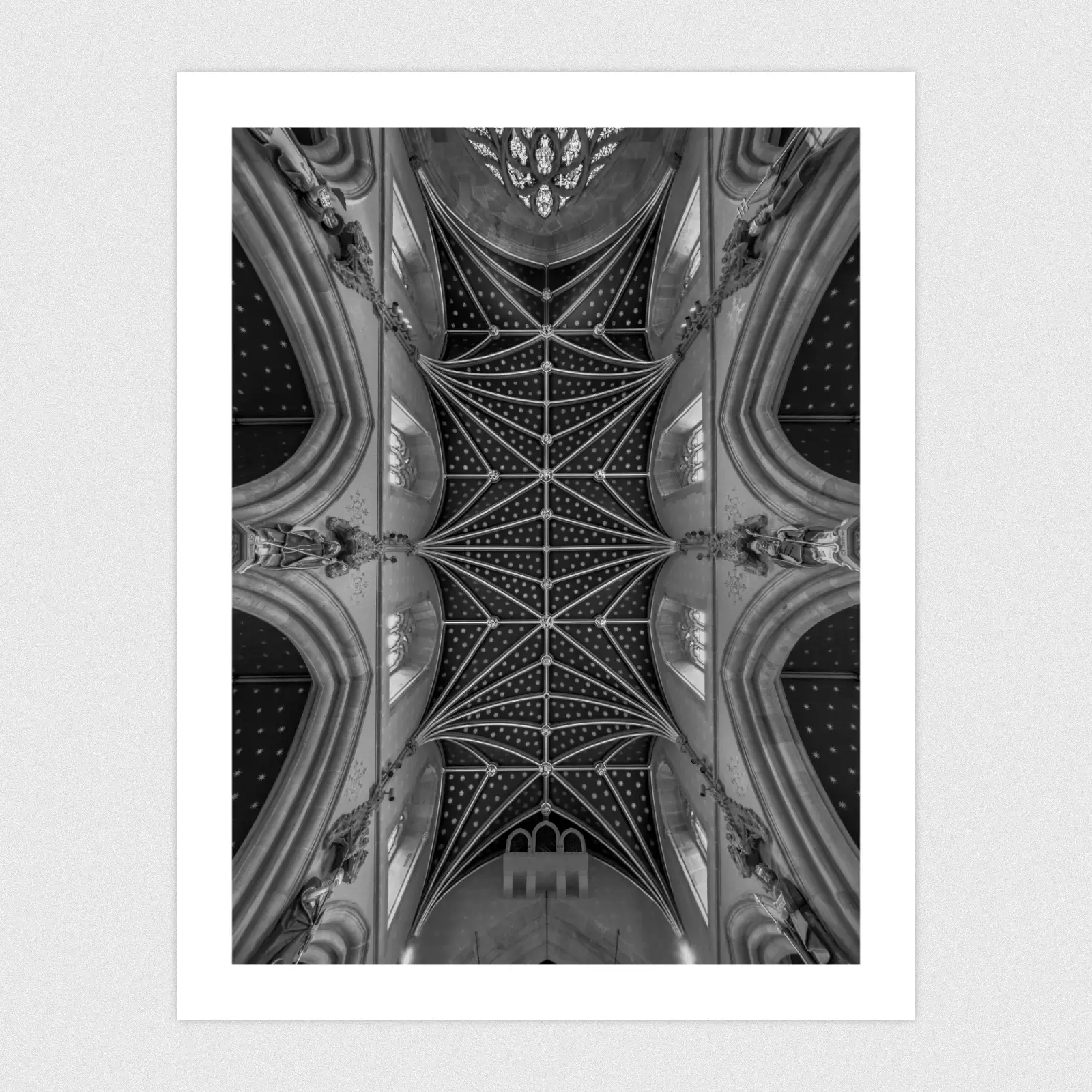 A black-and-white photo looking directly up at a symmetrical cathedral ceiling with neo-Gothic architecture.