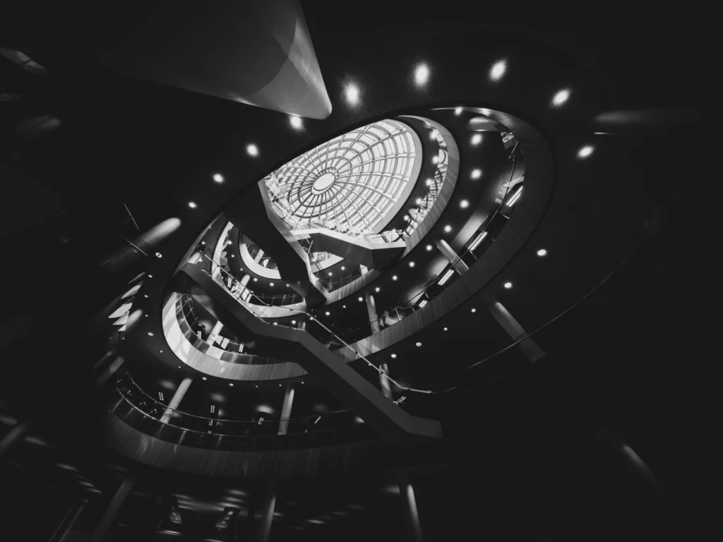 A black and white edit of the inside of Liverpool Central Library looking up towards a glass dome.