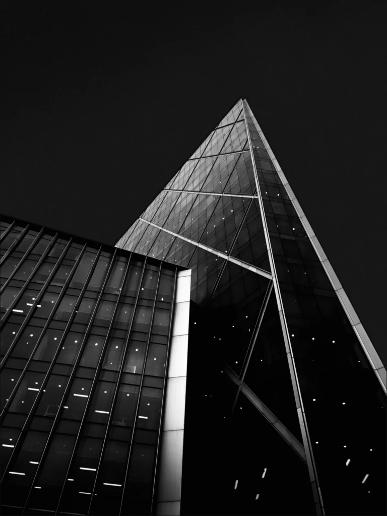 A dark mode edit of two overlapping buildings against a black background.