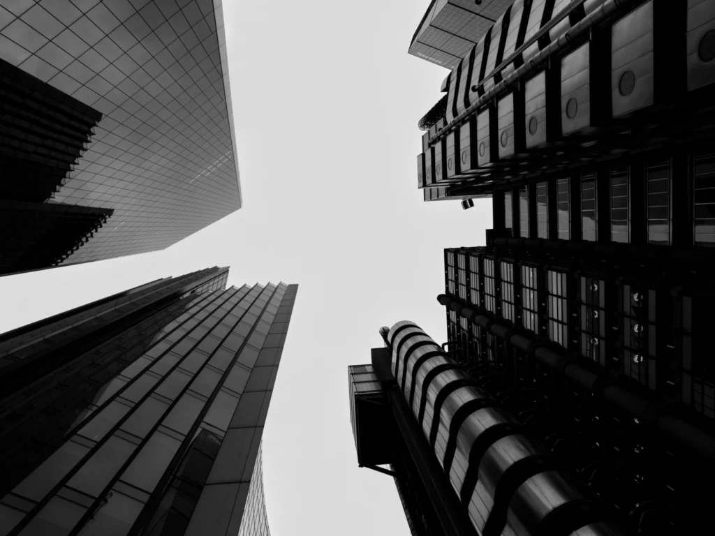 Black and white photo looking up at tall modern buildings in London.