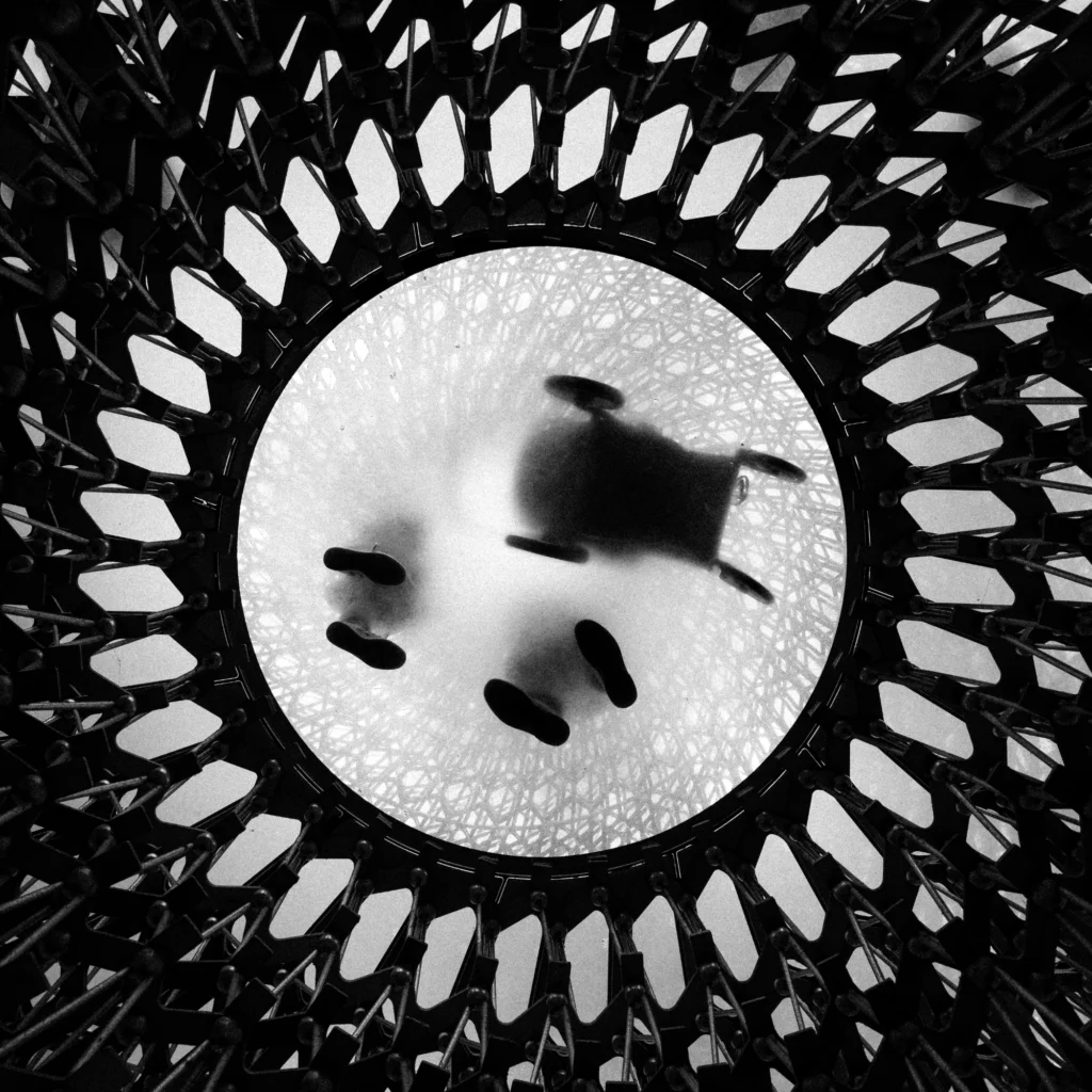 Looking up at people standing above on circular textured glass.