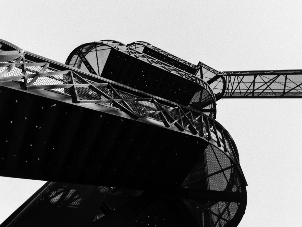 Looking up at an outside staircase leading to a treetop walk.